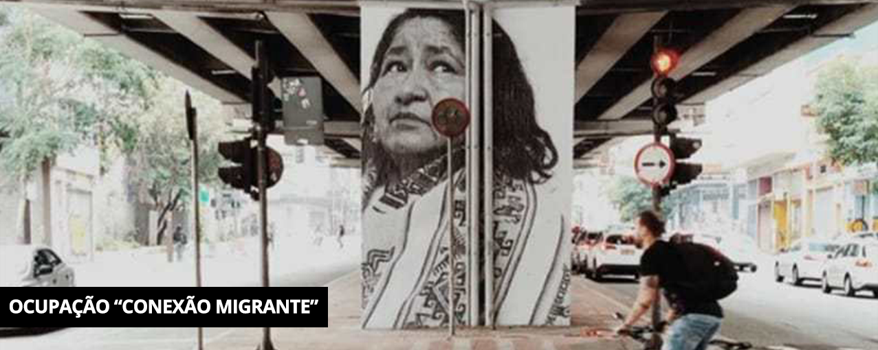 Fotografia retangular, colorida, mostrando a aplicação de uma fotografia da Diana Soliz, migrante boliviana, no Minhocão